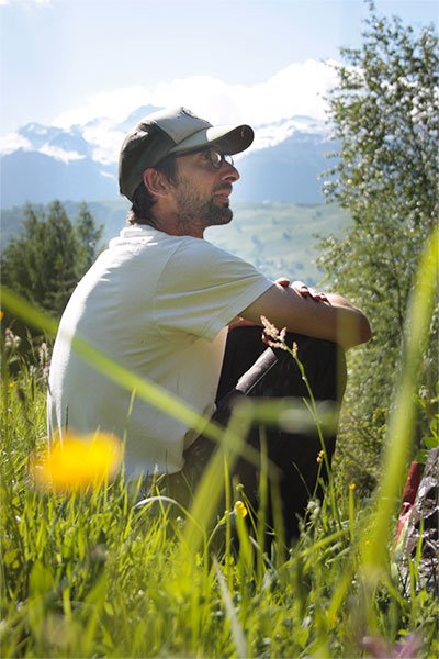 Philippe Bodon assis dans l'herbe pendant la cueillette Maison M