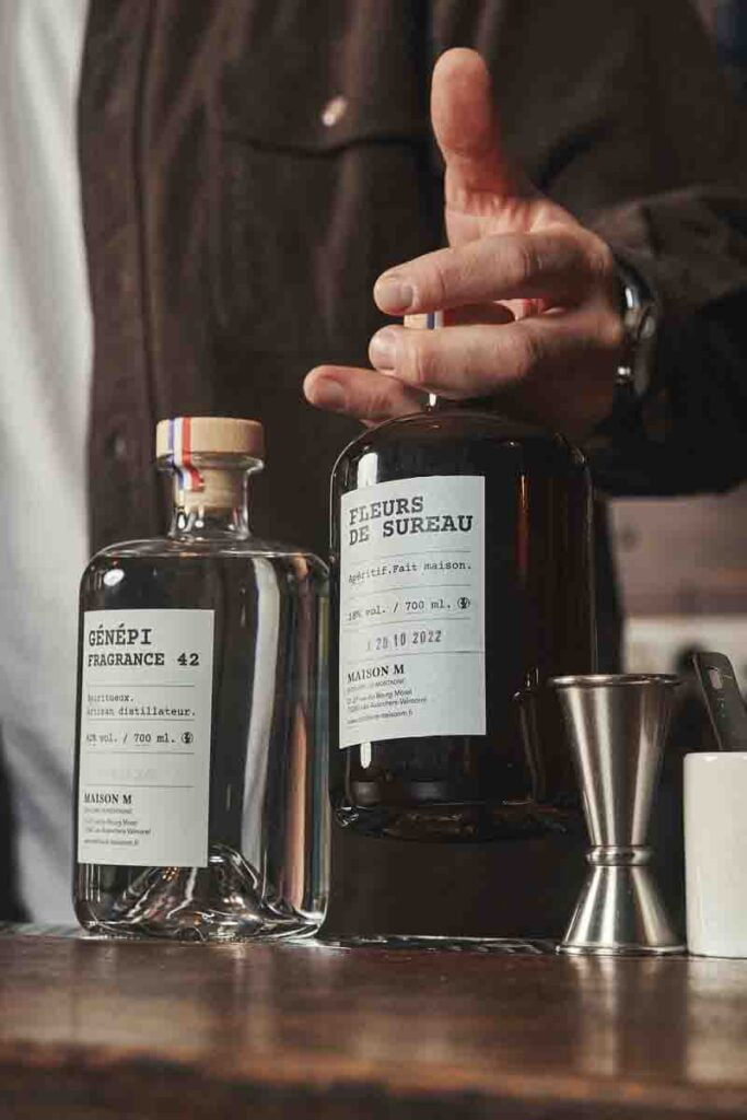 deux bouteilles d'alcool, une de génépi fragrance 42 et une autre de fleur de sureau