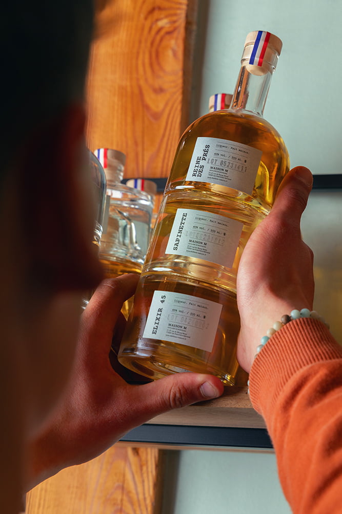 Photo d’un homme dans une distillerie en train de tenir des flacons de spiritueux.