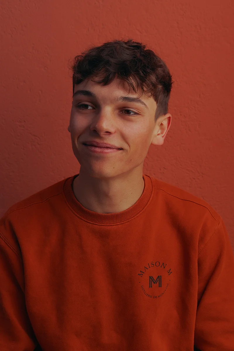 Photo de Jessy Matrat devant la distillerie Maison M.